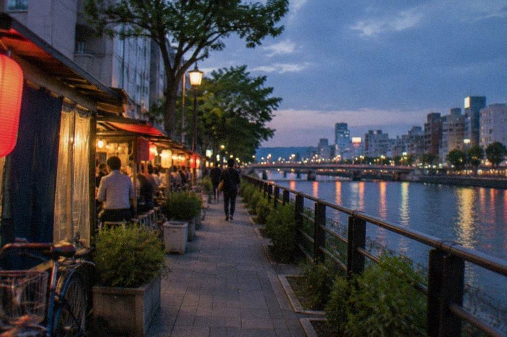 Naka River at dusk with illuminated food stalls lining the waterfront promenade