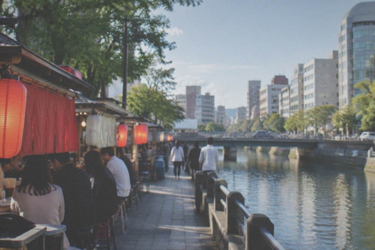 Canal-side street food stalls glowing at night beside the river in central Fukuoka