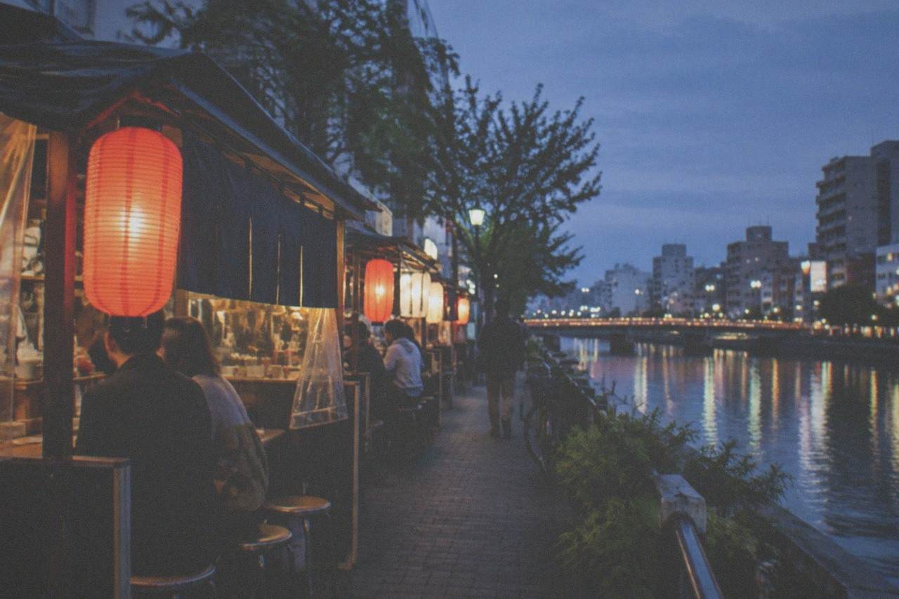 Canal-side food stalls glowing along the Naka River in Fukuoka at dusk