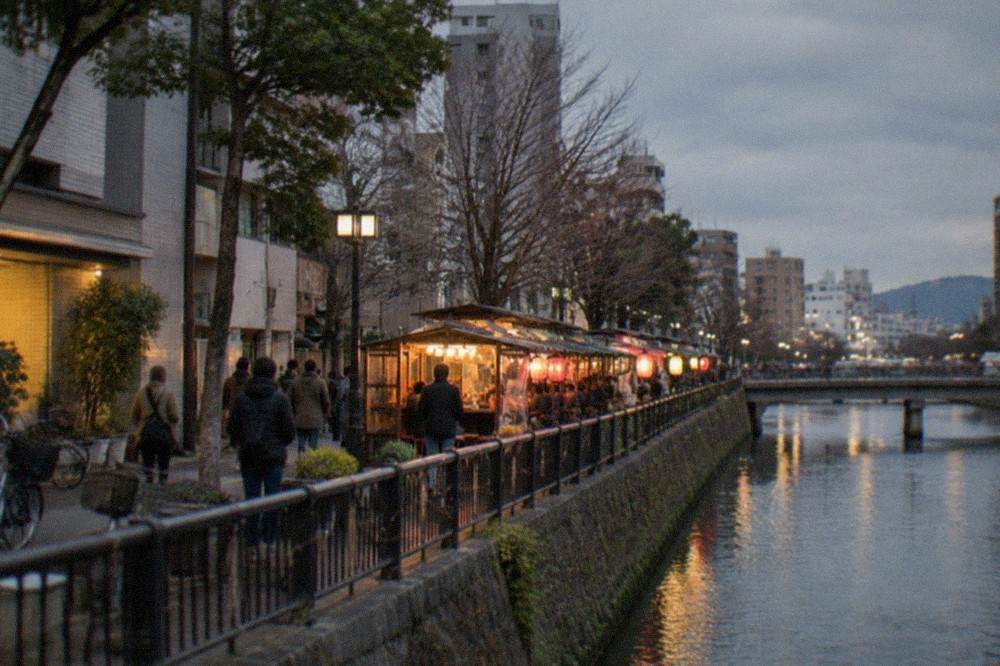 Food stalls glowing along the riverbank on a cold evening in winter