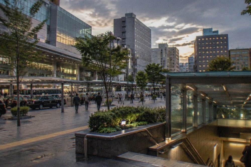 Hakata Station district skyline with hotel towers and the subway entrance at dusk