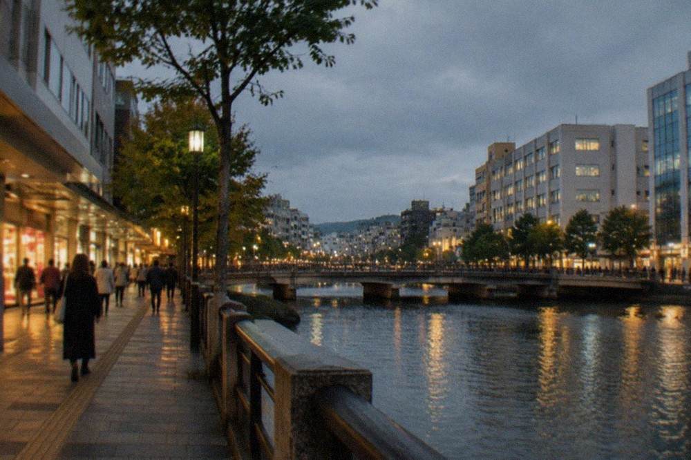 Tenjin shopping street with illuminated storefronts and the Naka River at night