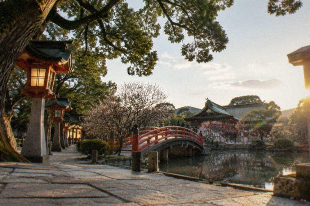 The lantern-lit approach to Dazaifu Tenmangu with its arched bridge over the pond