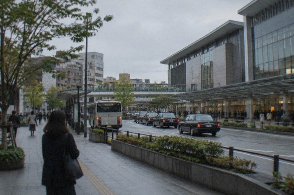 The Hakata Station building exterior with a departures board and taxi rank