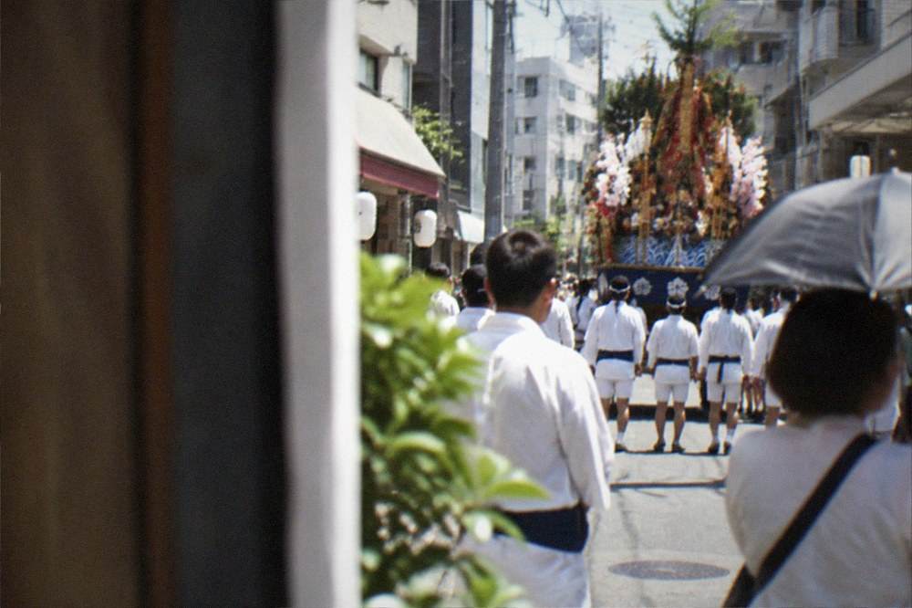 Decorated festival float displayed on a city street with crowds