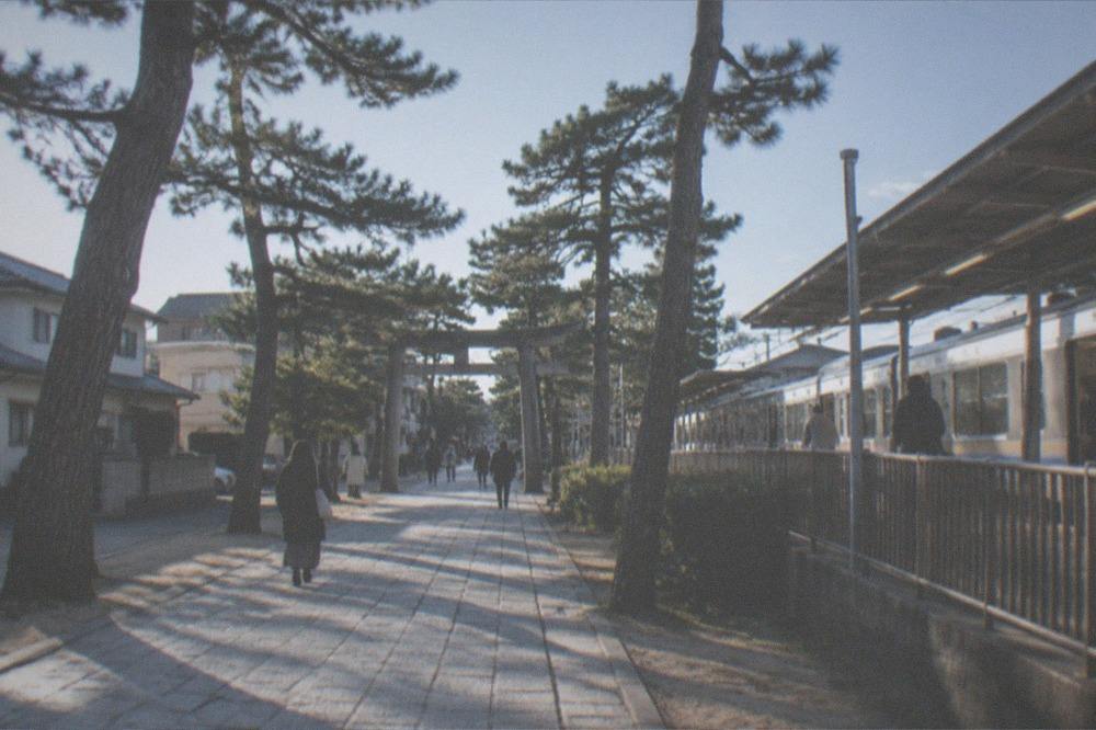 A subway platform in Fukuoka with a train waiting and signage overhead