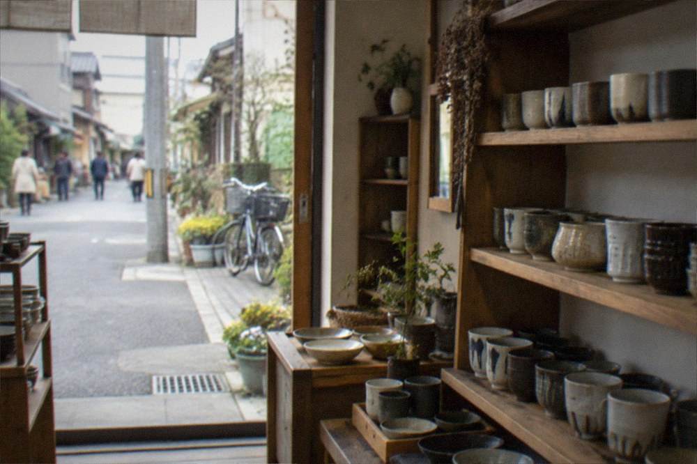 A ceramics and homeware shop interior in Imaizumi with handmade cups arranged on wooden shelves