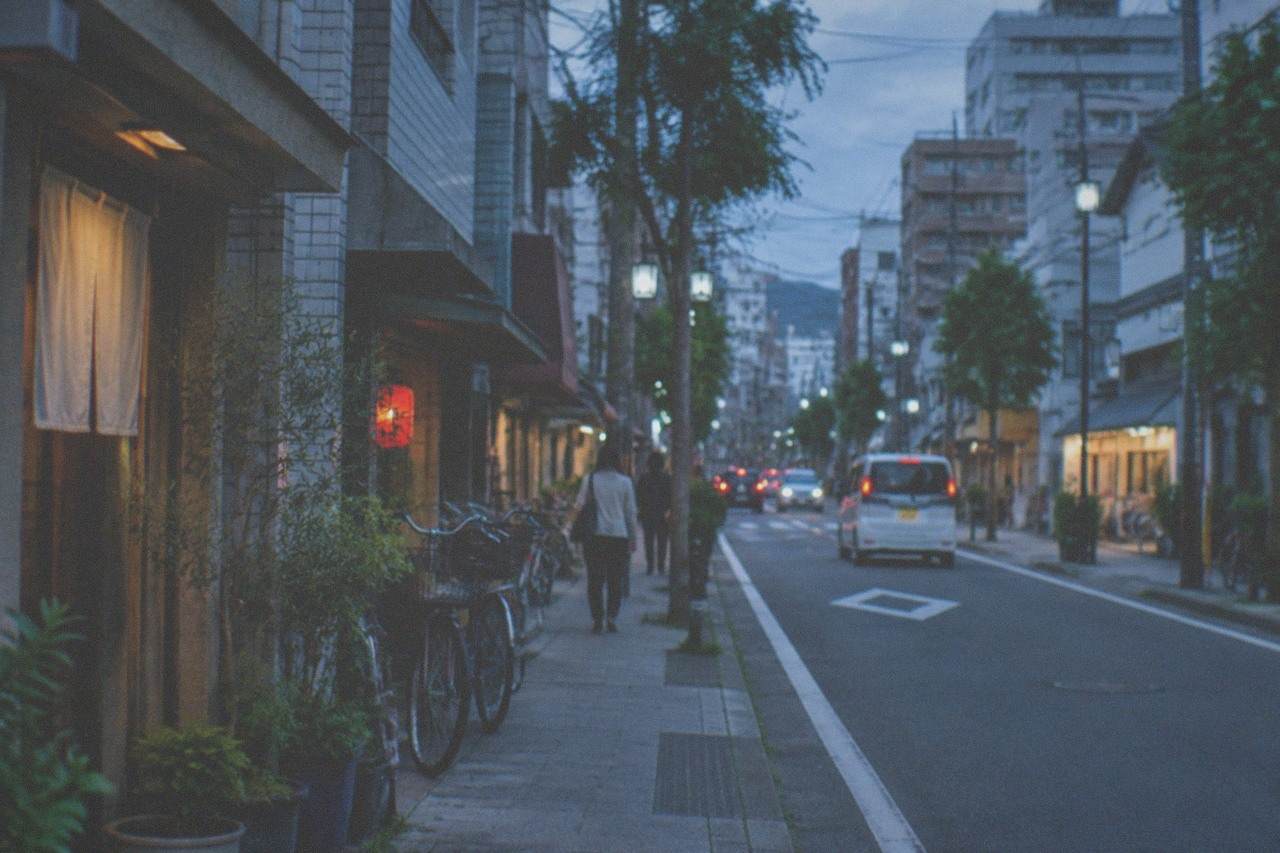 Neon signs reflecting on the Naka River with illuminated food stalls along the waterfront