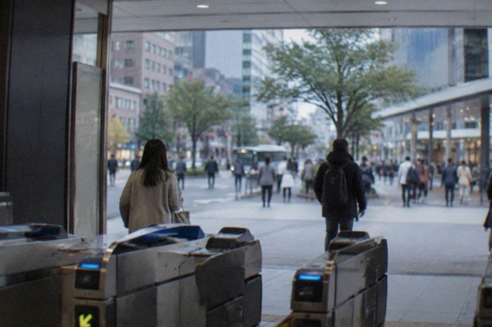 A subway station concourse in central Fukuoka with fare gates and overhead signs