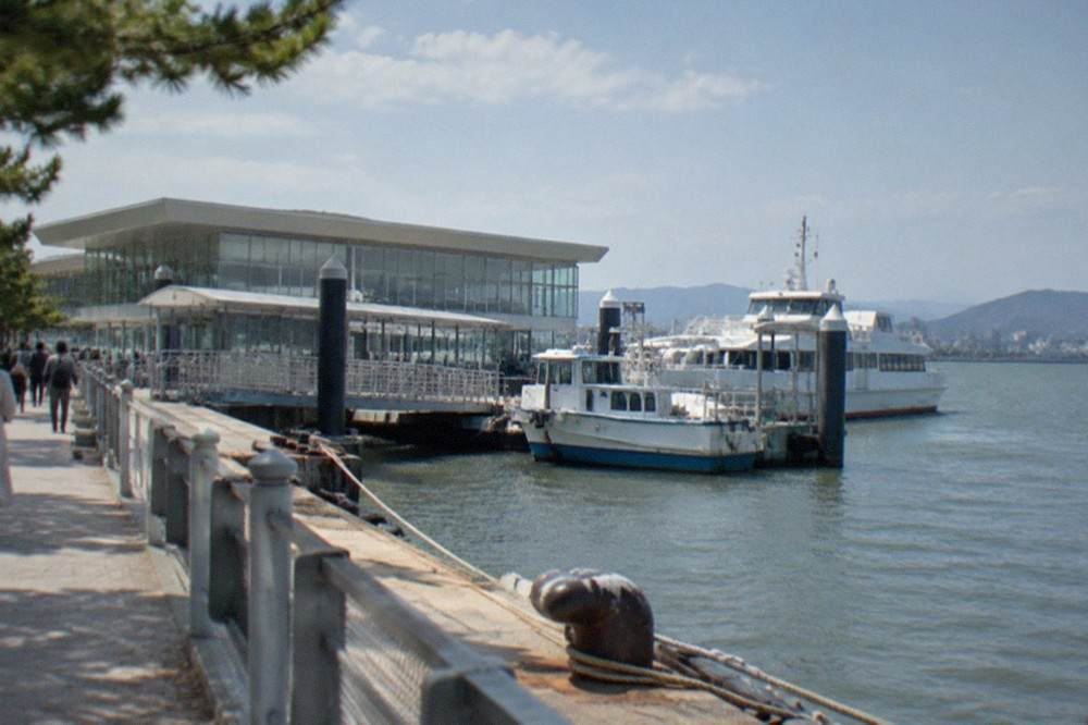 Ferry terminal building with glass walls and boats tied up along the pontoon