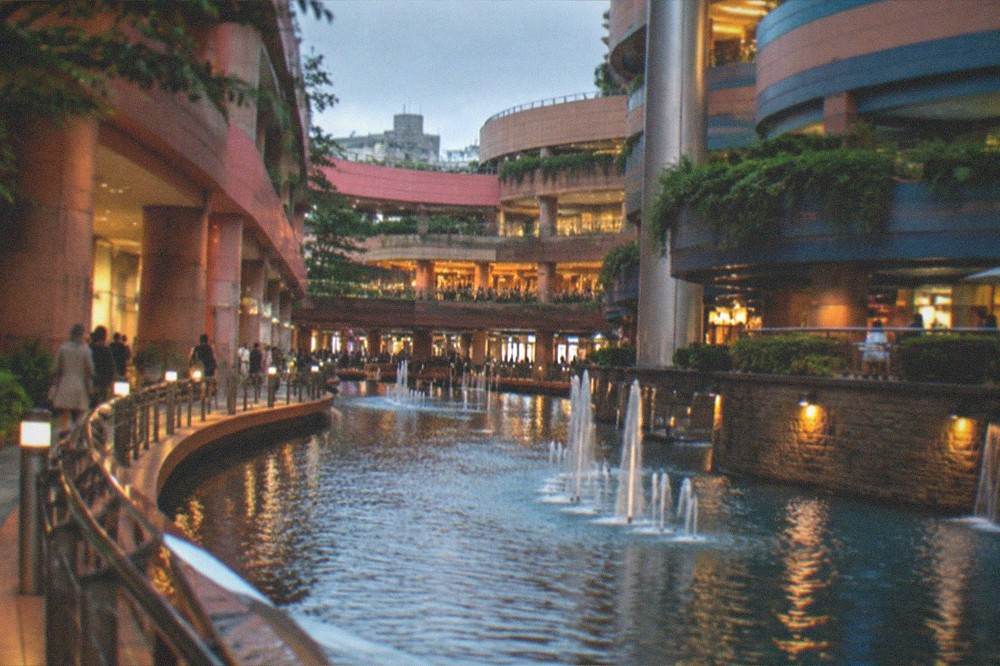 A canal-side walkway at dusk with lights reflecting on the water