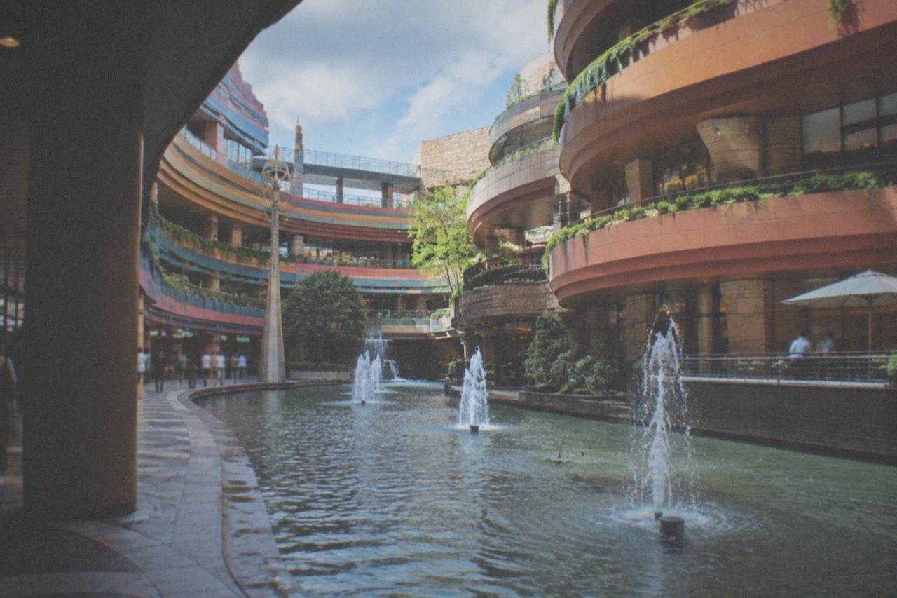 A modern shopping complex built around a curved canal running through its middle