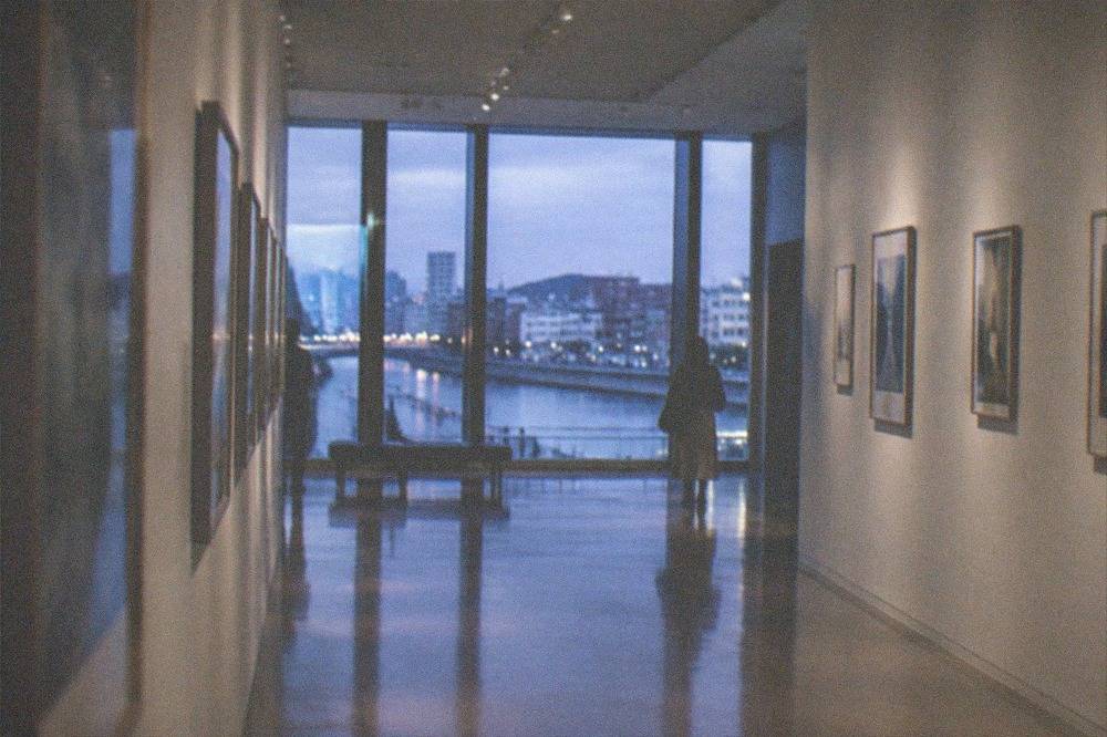 Gallery corridor with framed artworks on both walls and polished floor