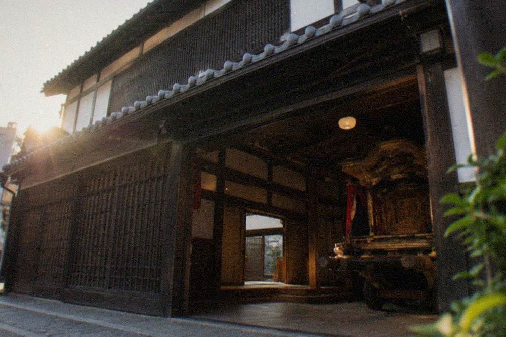 Wooden festival float displayed inside a traditional machiya building