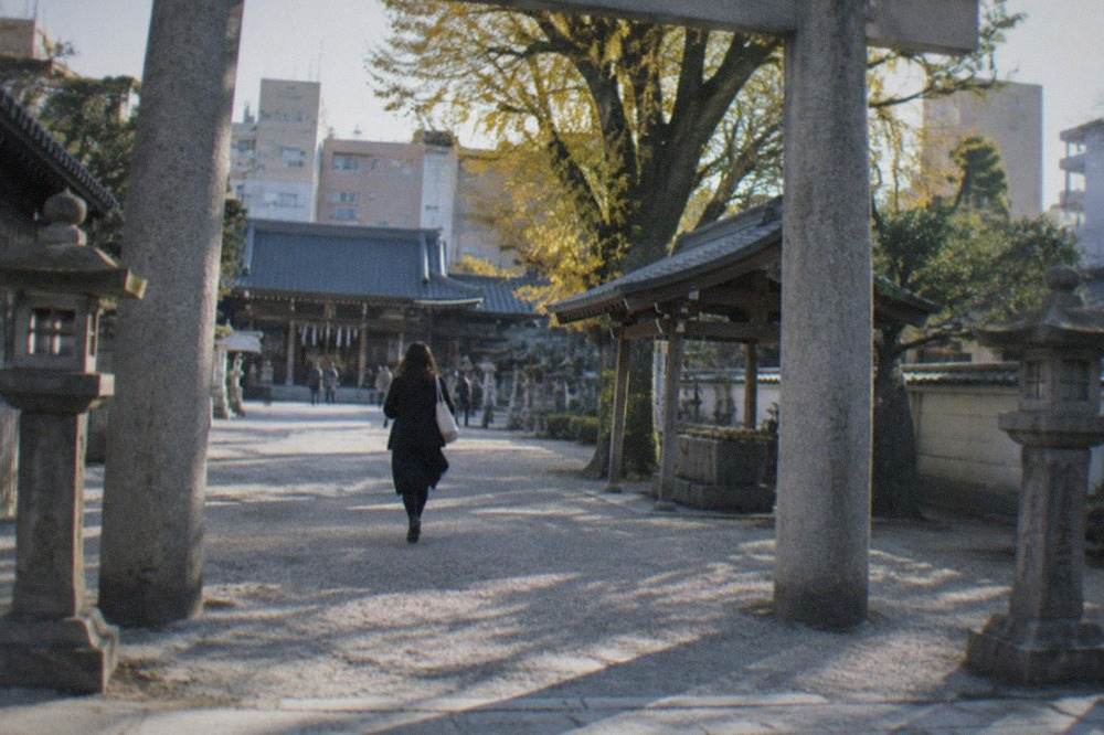 Stone torii gate and lanterns at the entrance to Kushida Shrine