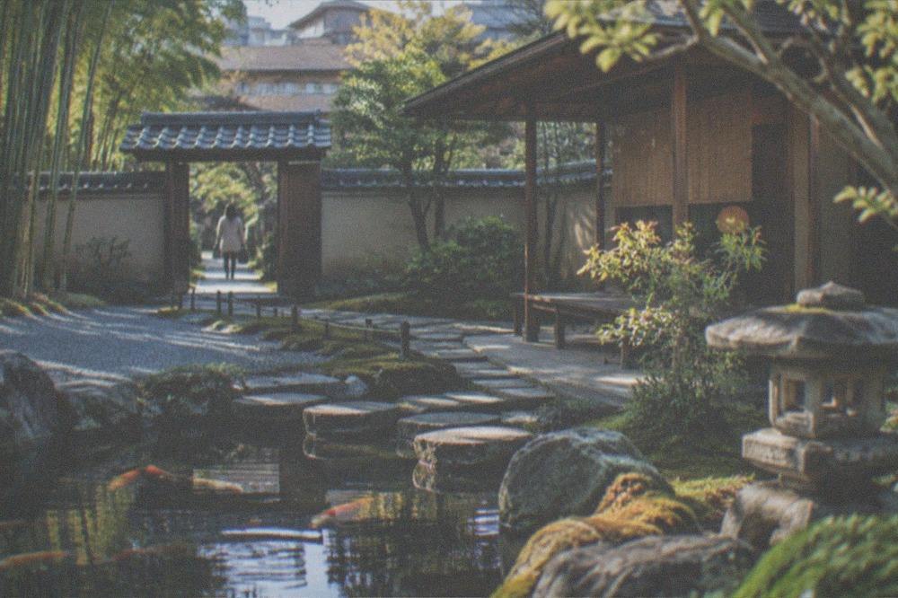 A bamboo grove edge and raked gravel beside a garden entrance gate