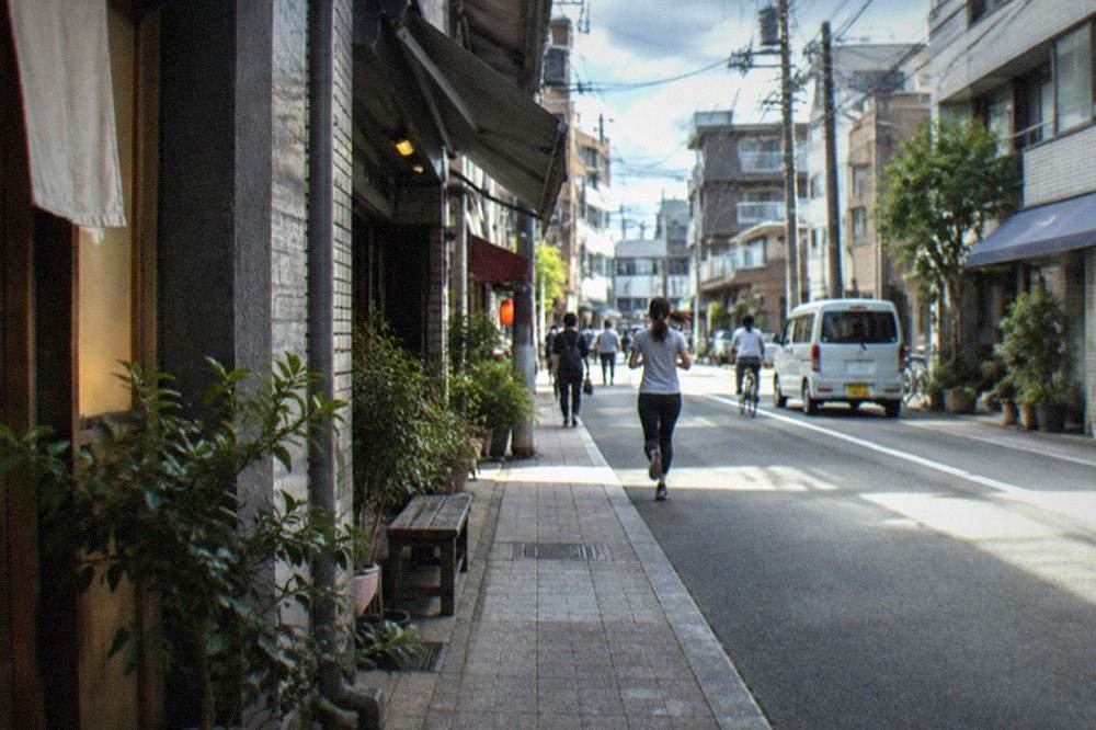 Sake barrels and stone monuments arranged beside a shrine hall in Hakata