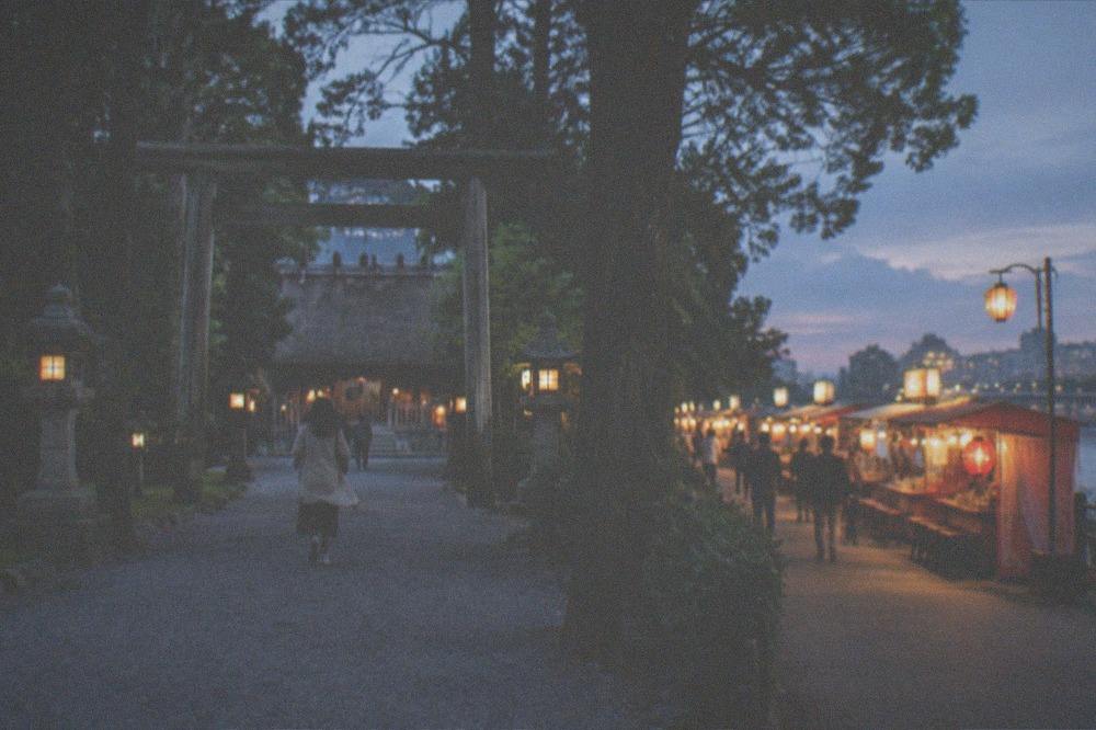 Evening lanterns glowing along a street of food stalls near the Naka River