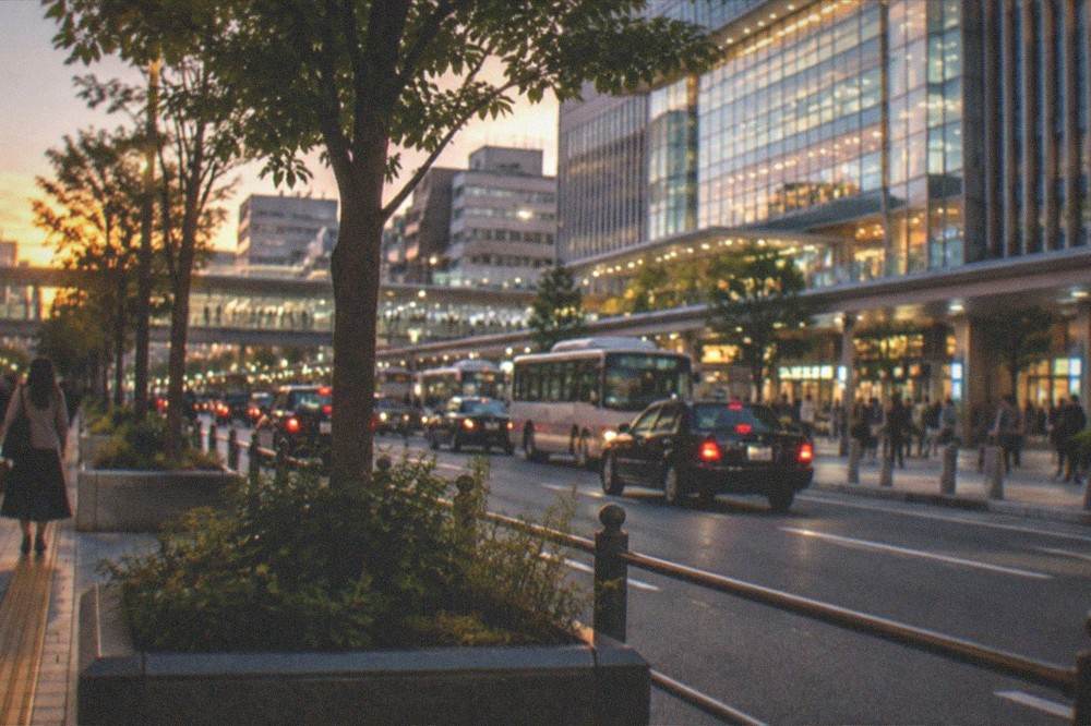 A night view of Hakata Station area with illuminated buildings and a busy street
