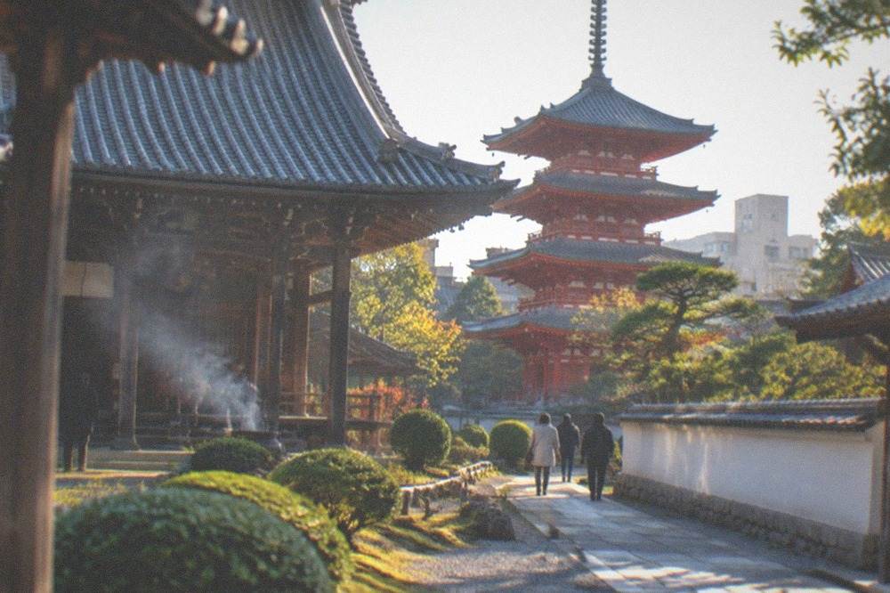 Incense smoke rising in front of a wooden temple hall