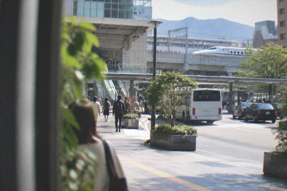 Bullet train waiting at a platform with mountains visible past the end of the tracks