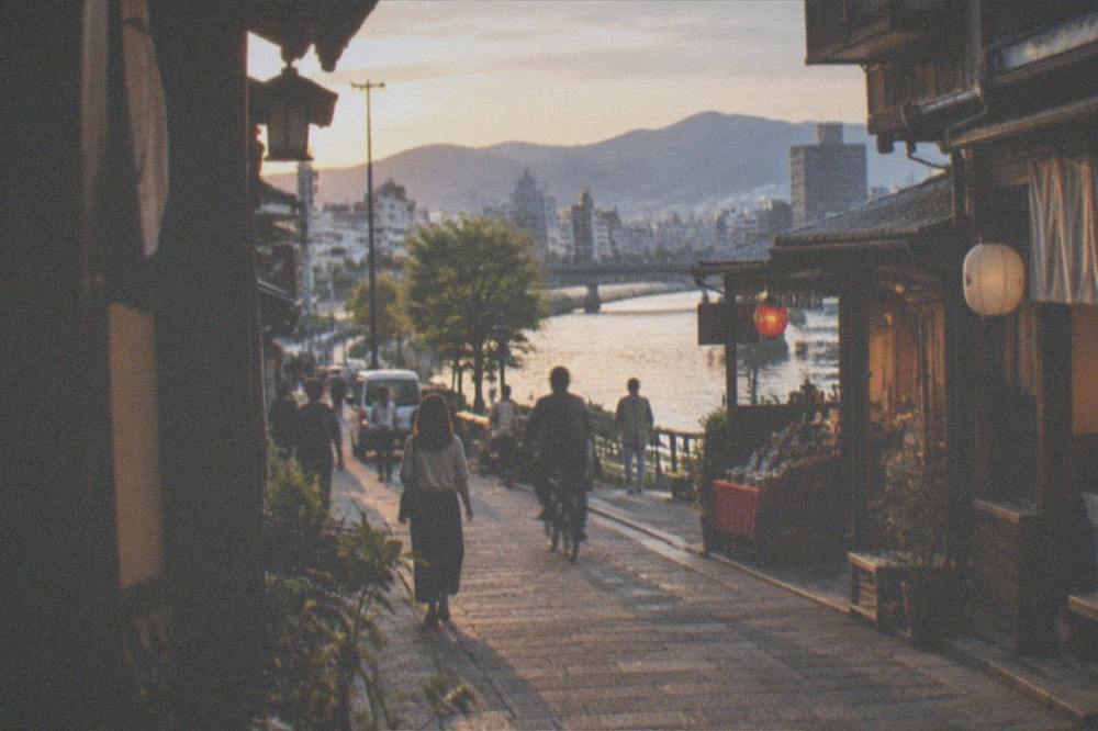 A small island street lined with wooden shopfronts and lanterns in late afternoon light