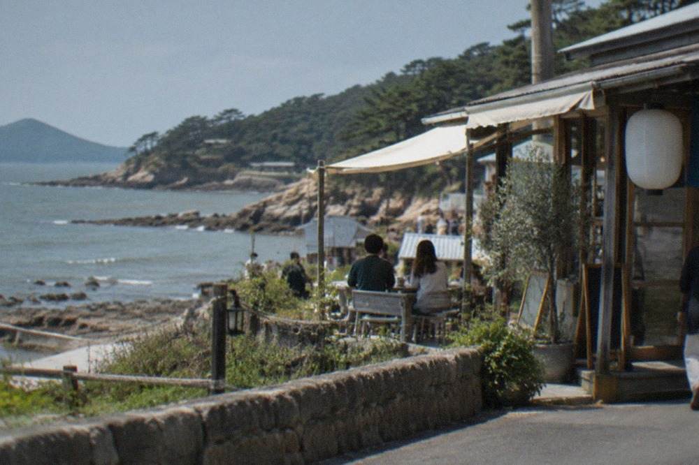 Rocky coastline with calm blue water and pine trees along a peninsula in western Japan