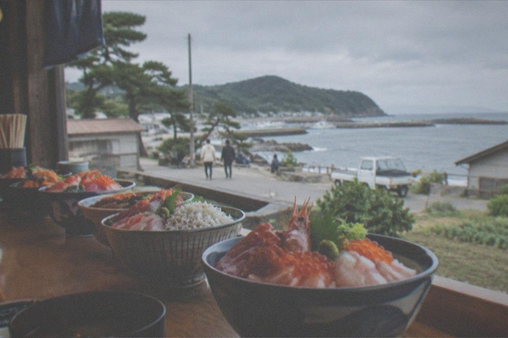Fresh seafood bowls lined up on a wooden counter in a small harbour restaurant