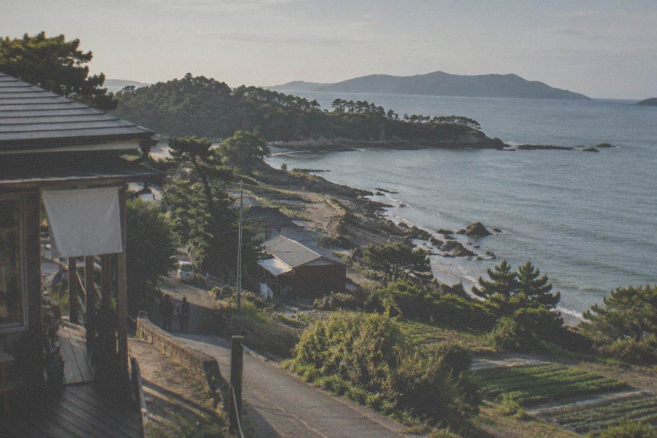 Rocky coastline with calm blue water and pine trees along a peninsula in western Japan