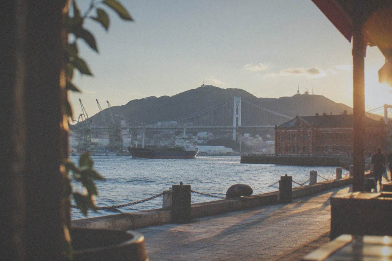 Historic red-brick harbour buildings along a waterfront promenade under a clear sky