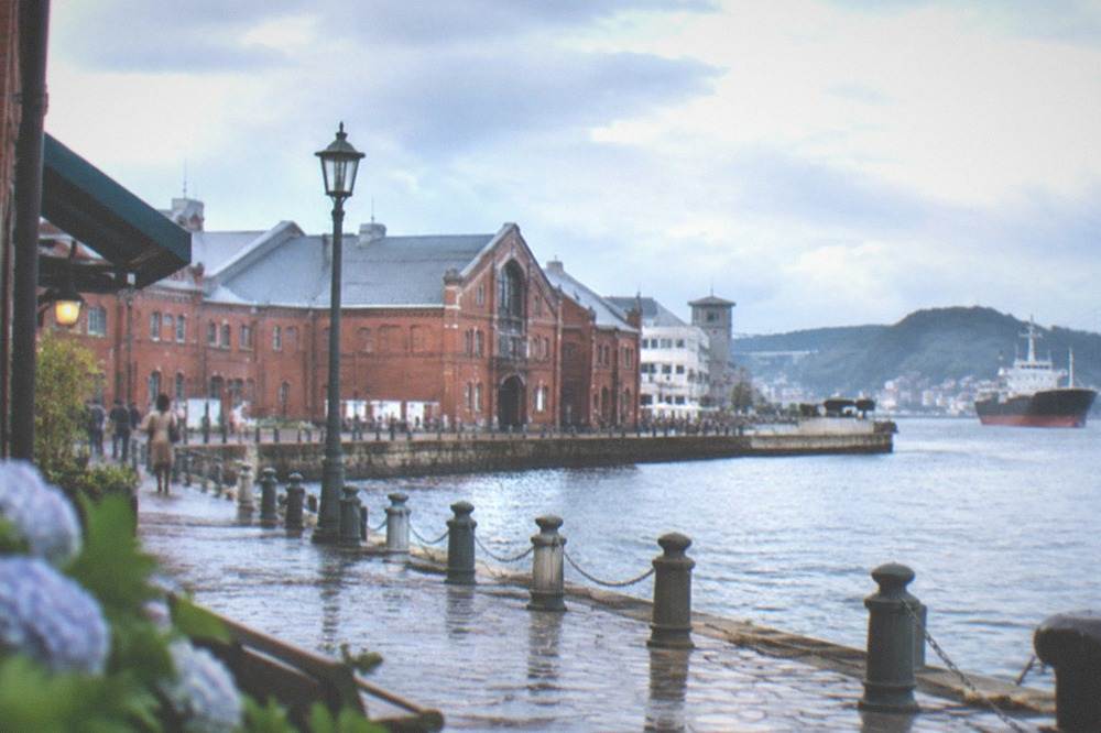 Red brick historic warehouses along the waterfront at Mojiko with the strait beyond