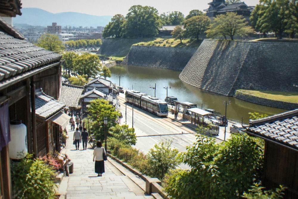 Traditional wooden buildings and a stone-paved street in a historic castle-town district