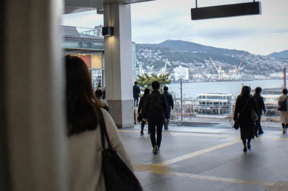 Passengers walking through a modern railway station concourse with departure boards