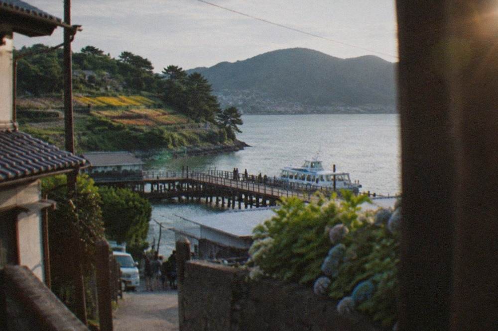 Wooden ferry dock at Meinohama with a small passenger boat and calm bay water