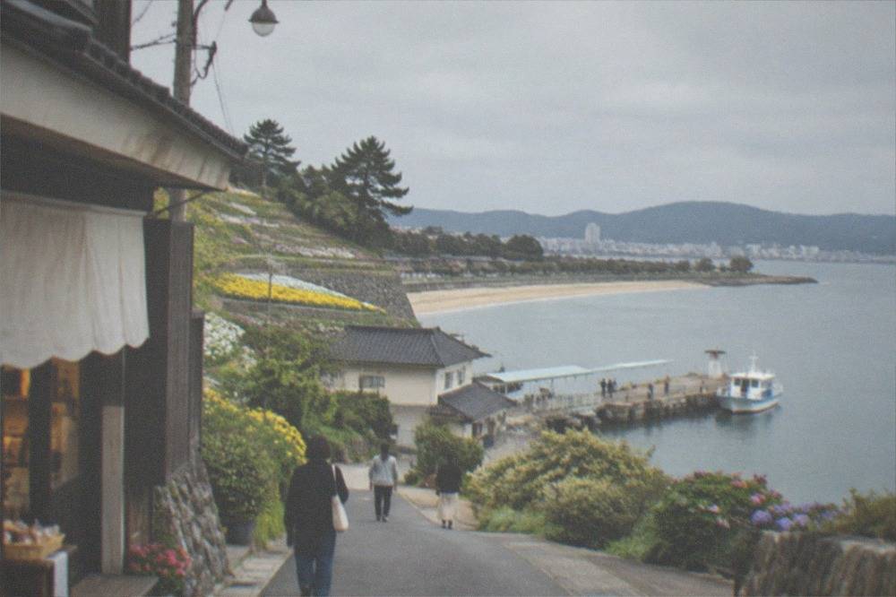 Sandy beach on an island shore with calm water and a distant city skyline