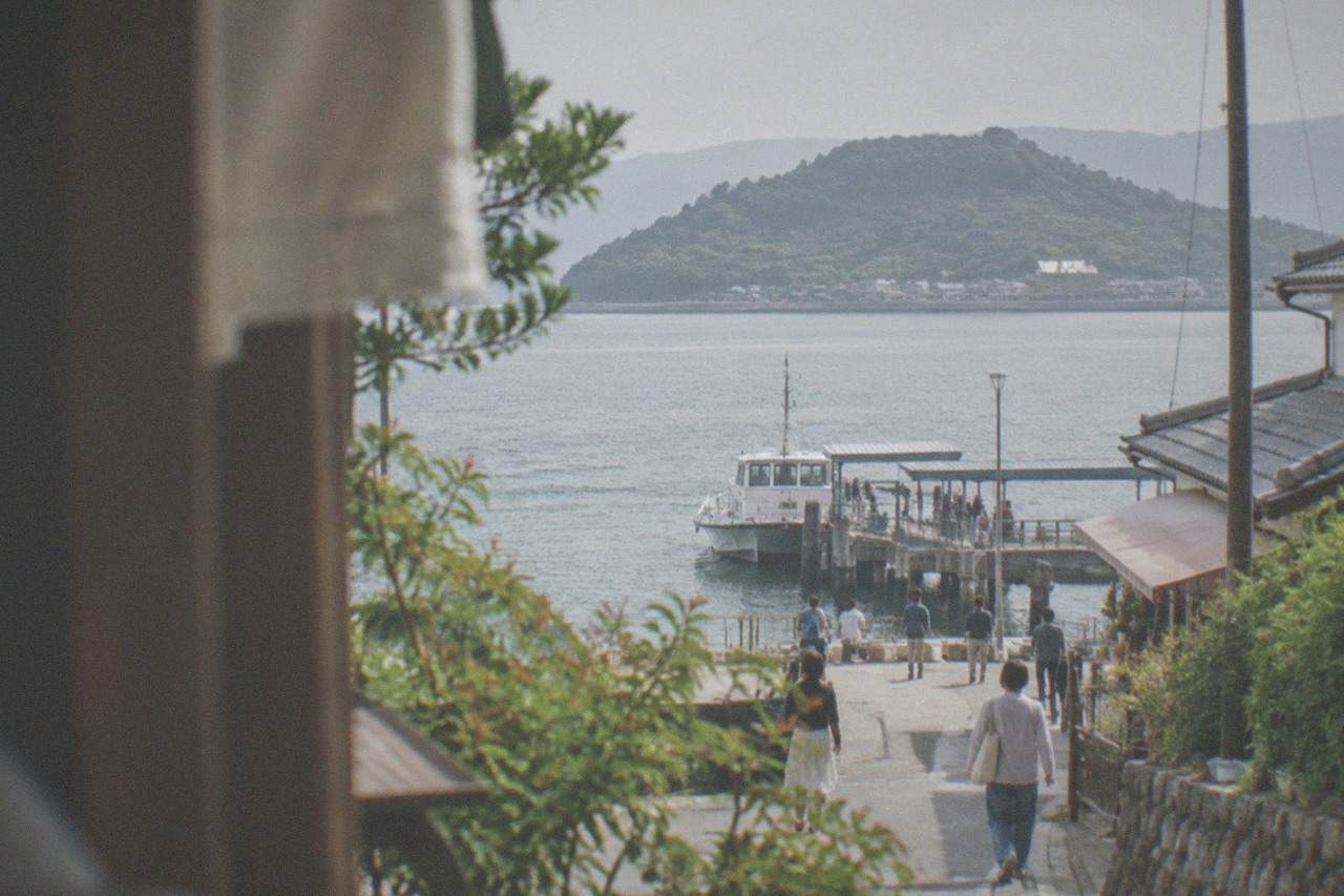 Wooden ferry dock at Meinohama with a small passenger boat and calm bay water