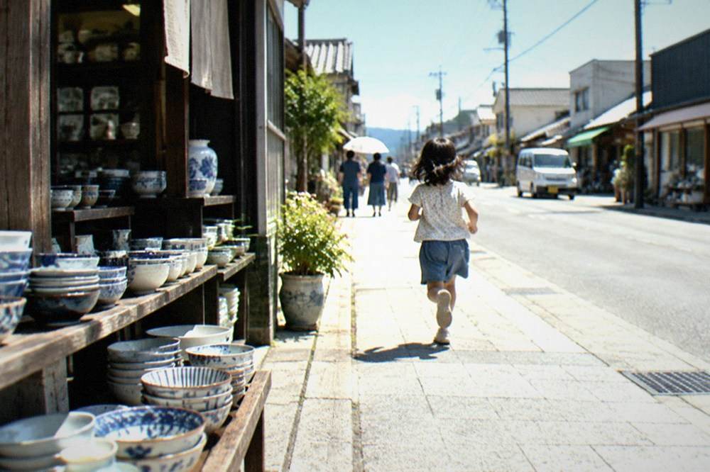 A quiet ceramics shopping street with shopfronts displaying stacked porcelain bowls