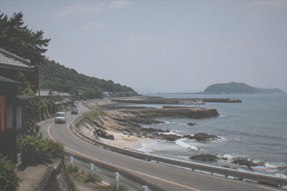 Open sea horizon from a grassy headland with waves breaking on rocks below