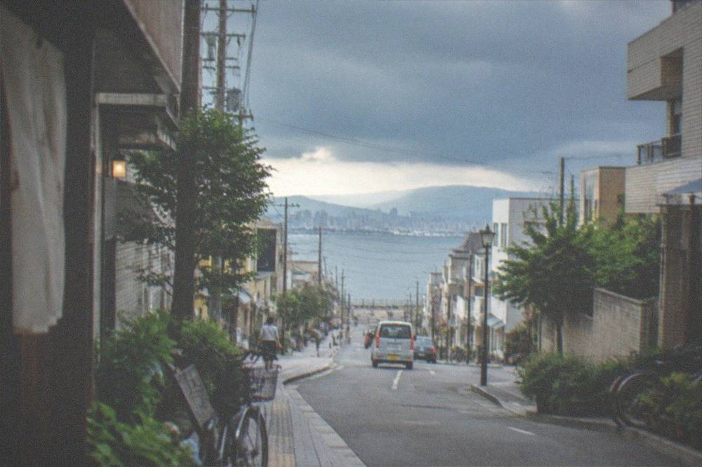 Dark storm clouds gathering over a bay with a city skyline beyond