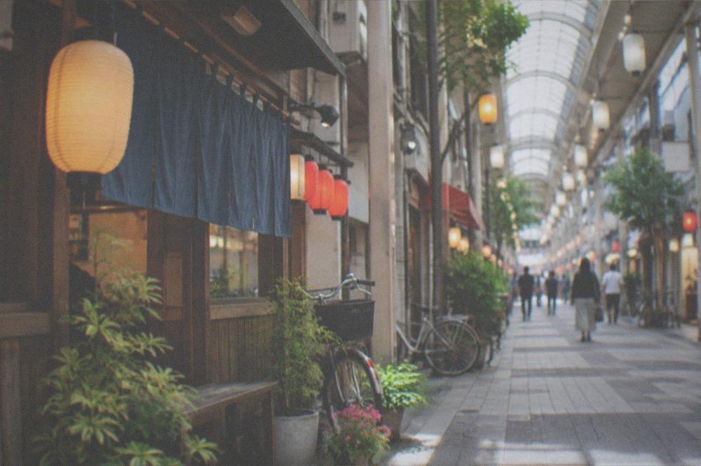 A covered shopping arcade street lit at night with lanterns and small food stalls