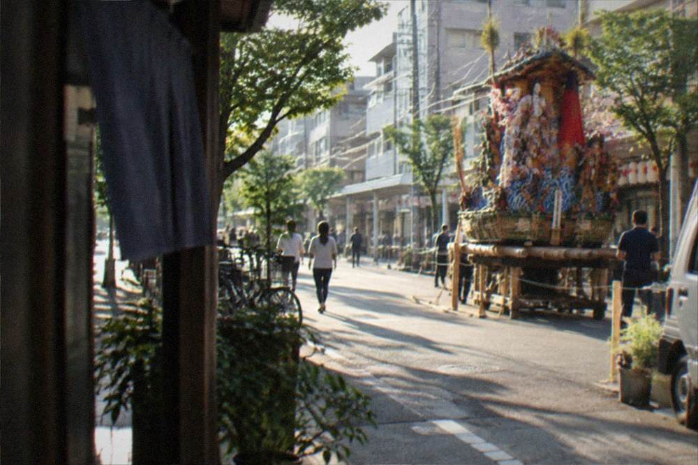 Tall decorated festival float displayed on a city street