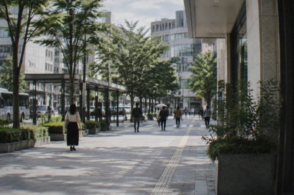 Wide smooth plaza in central Fukuoka with an empty accessible walkway beside modern buildings