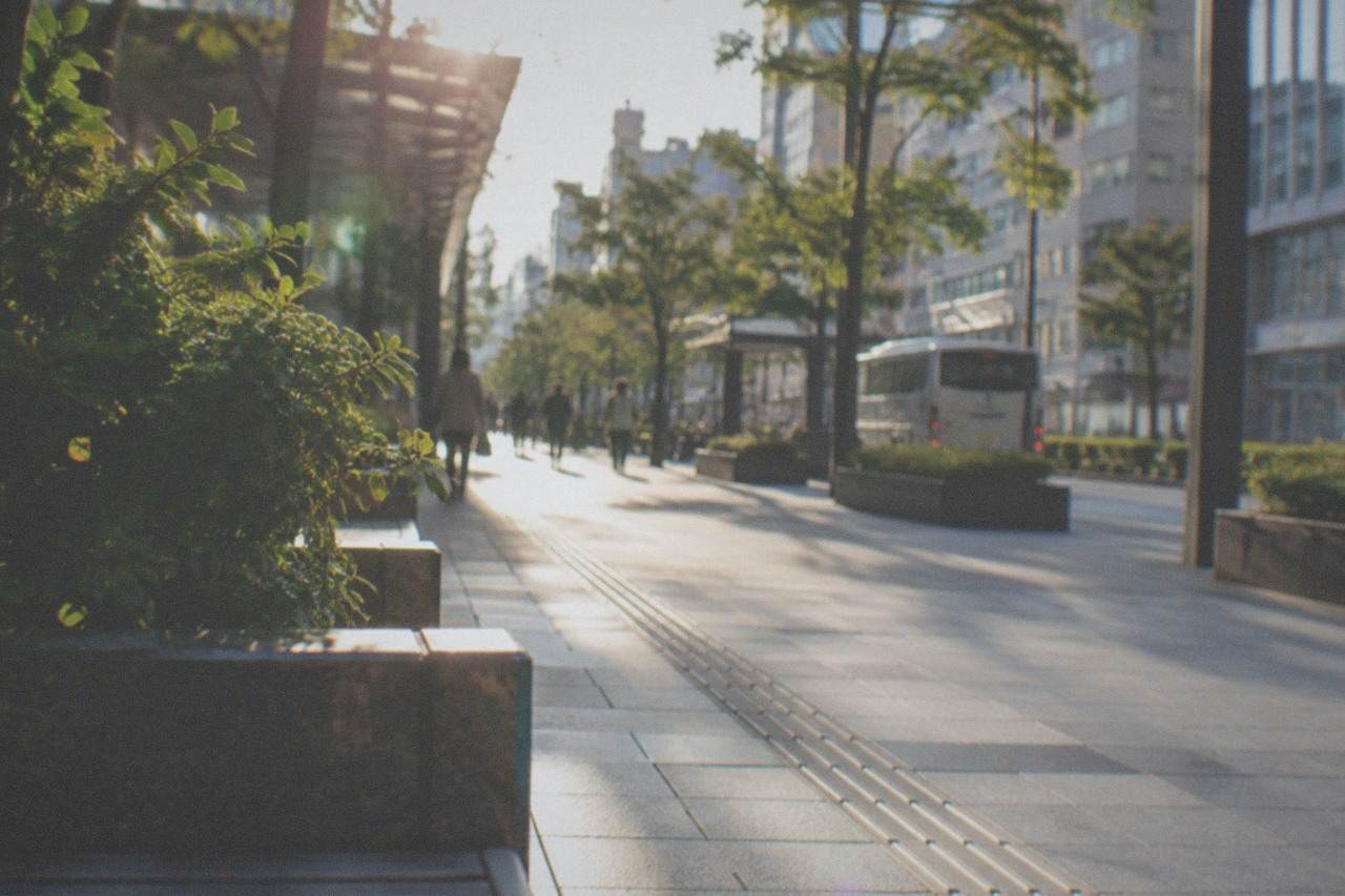 Wide smooth plaza in central Fukuoka with an empty accessible walkway beside modern buildings