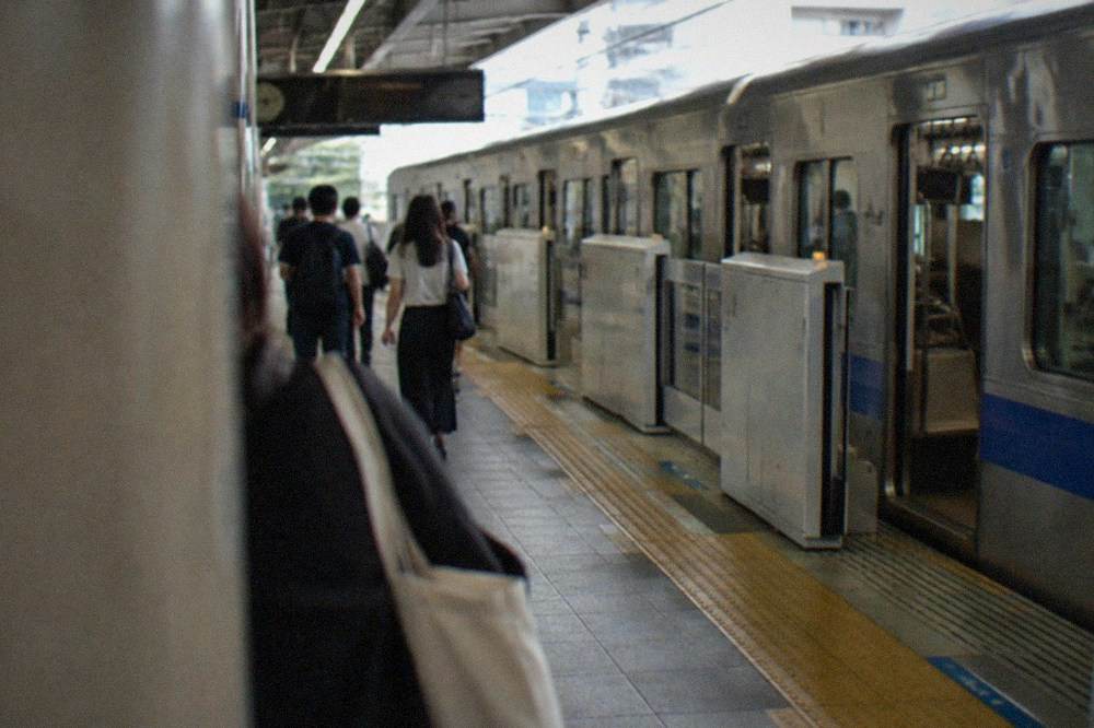 A subway platform at Fukuoka Airport Station with a train waiting