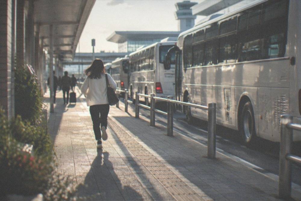 A row of airport shuttle buses outside a Fukuoka Airport terminal