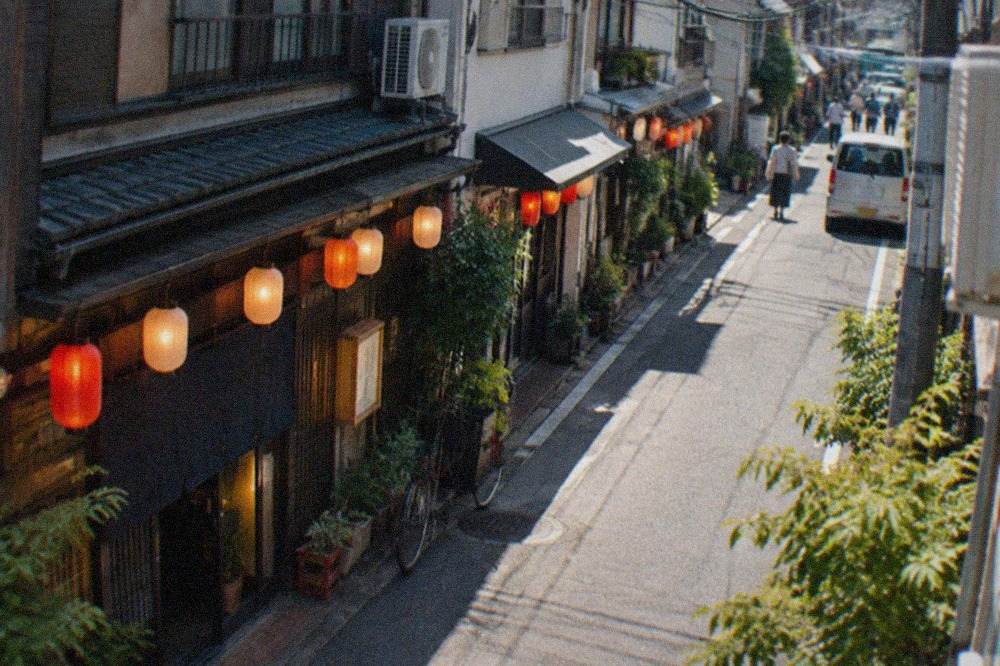 Izakaya lanterns glowing along a narrow street in the Daimyo district at night