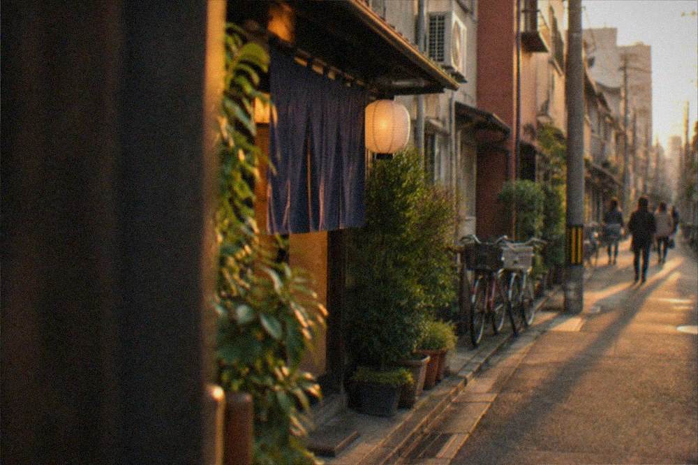 Small bar entrance with a curtain and a lit sign in a narrow Daimyo lane