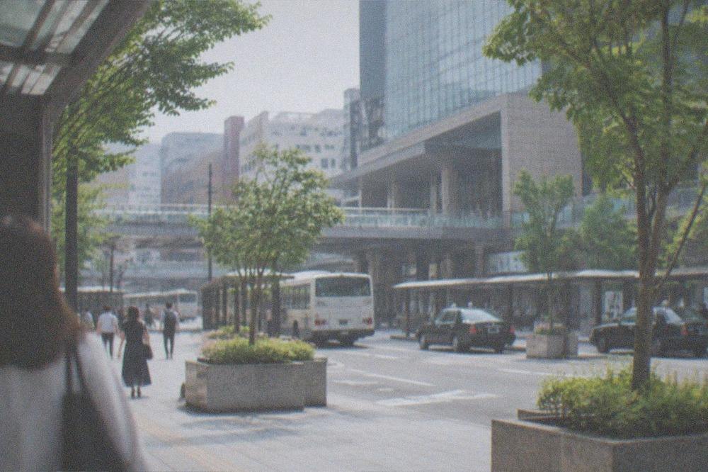 A bright airport arrivals hall with a subway station entrance sign visible beyond the gates