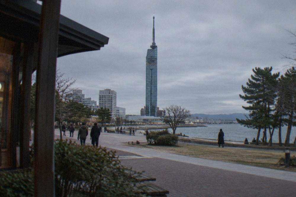 Fukuoka Tower illuminated at night seen across the Momochi waterfront