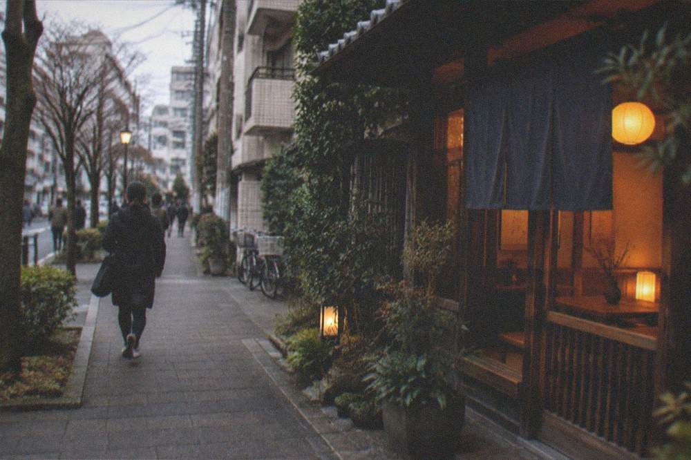 A cozy traditional tea room interior lit warmly against a dark evening outside